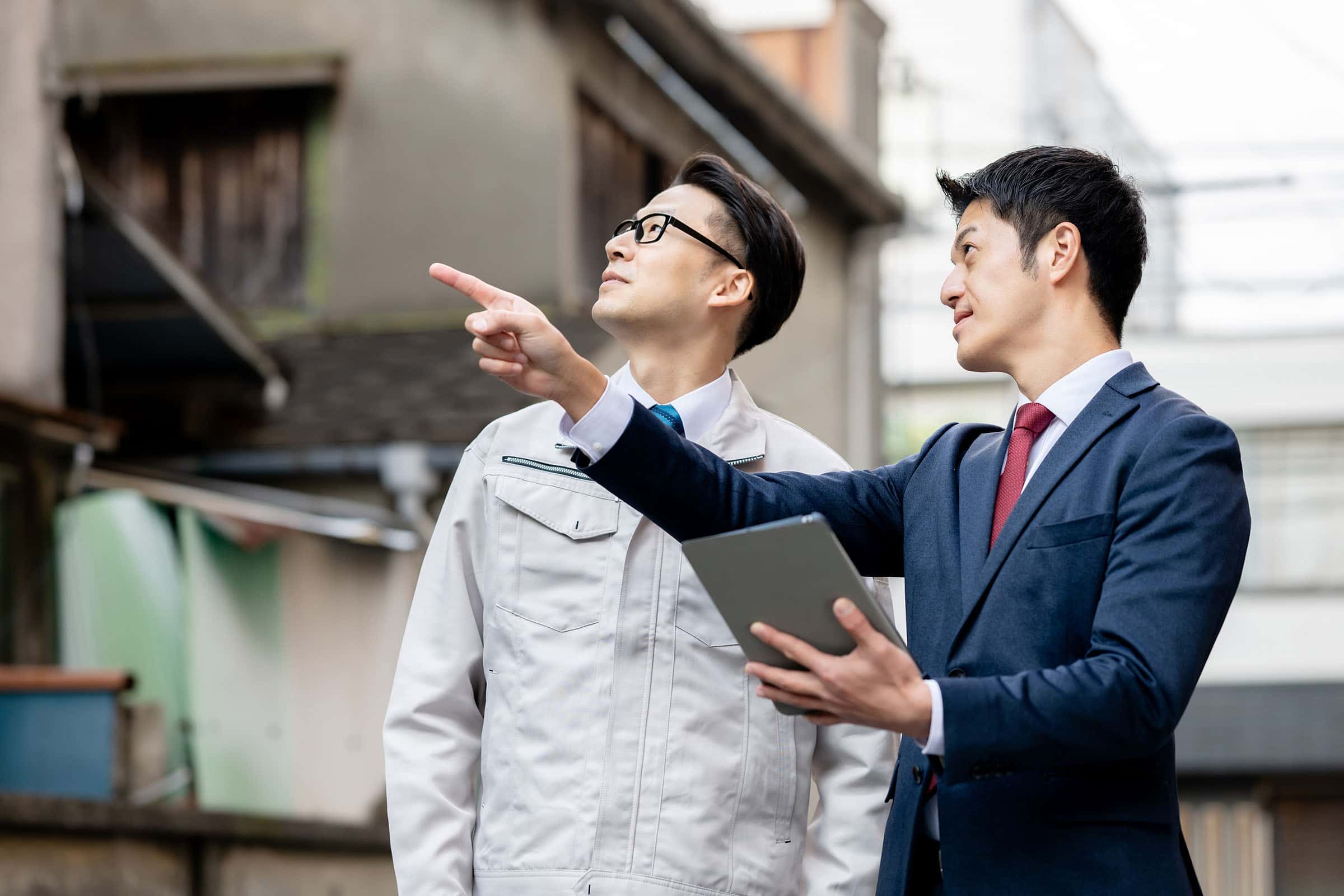 スーツの男性と作業着の男性